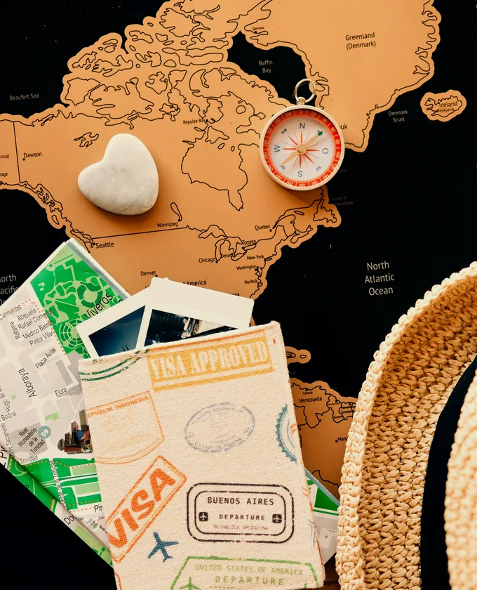 Reisepass mit Einreisestempeln, Kompass und Landkarte